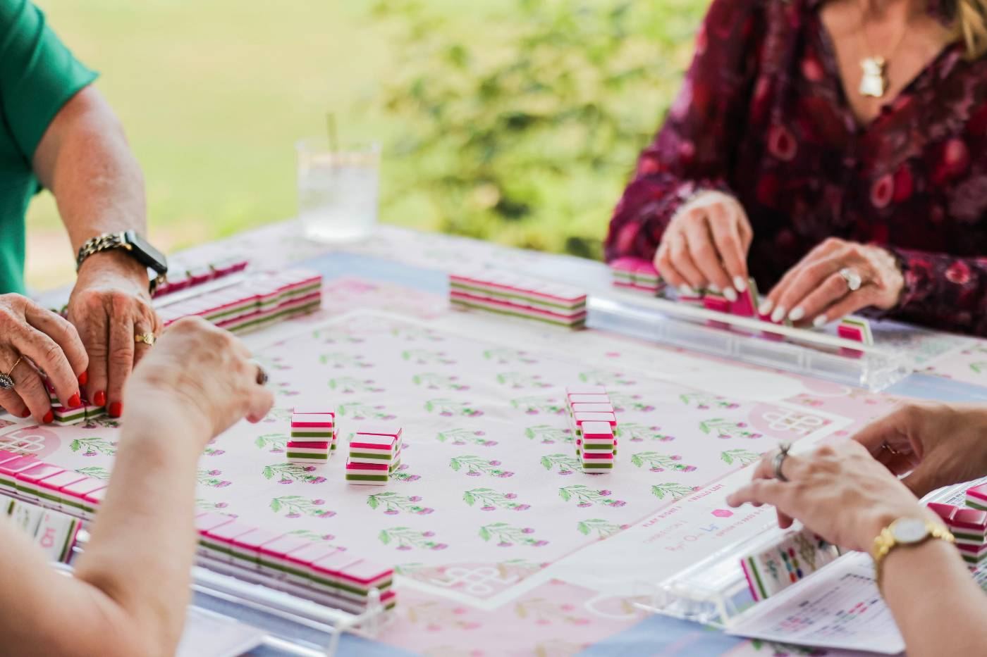 Mahjong tables set with pink and green tiles at an outdoor league night